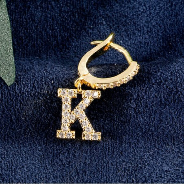 Złote kolczyki pokryte cyrkoniami literka K